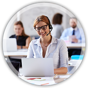Frau mit Brille und Headset sitzt lächelnd am Laptop Frau mit Brille und Headset sitzt lächelnd am Laptop