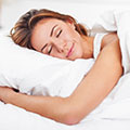 Brünette Frau schläft friedlich in weiße Bettwäsche gehült 
