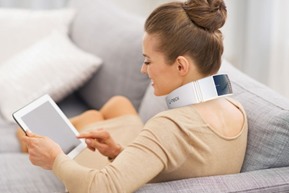 Frau trägt den U-neck Lite, sitzt dabei auf dem Sofa und liest entspannt Frau trägt den U-neck Lite, sitzt dabei auf dem Sofa und liest entspannt