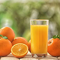 Ein Glas Orangensaft umgeben von ganzen und halben Orangen