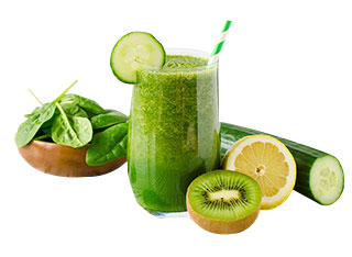 Grüner Smoothie in einem Glas neben einer Zitrone, einer Gurke, Spinat und einer Kiwi