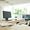 Helles offenes Büro mit Holztischen und Computerbildschirmen